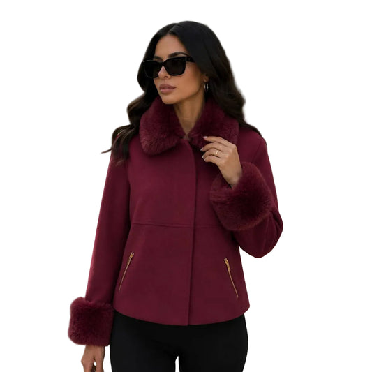 A woman modeling a burgundy faux-shearling jacket with plush faux-fur trim on the collar, cuffs, and hem, featuring gold zipper details on the front, set against a plain white background.